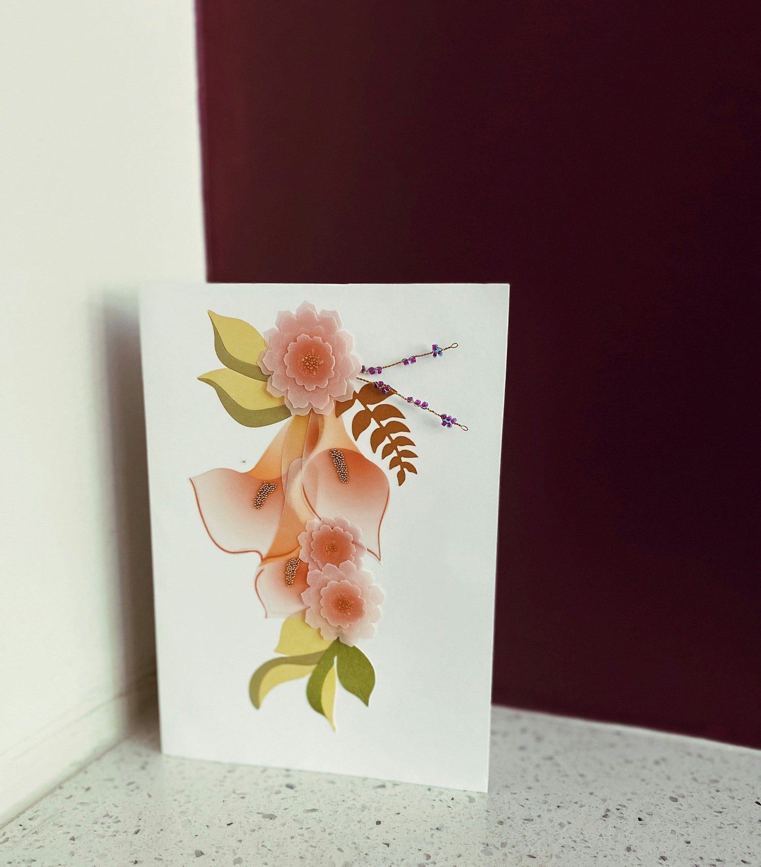 Minimal floral stationery card standing on a light surface with a soft background.